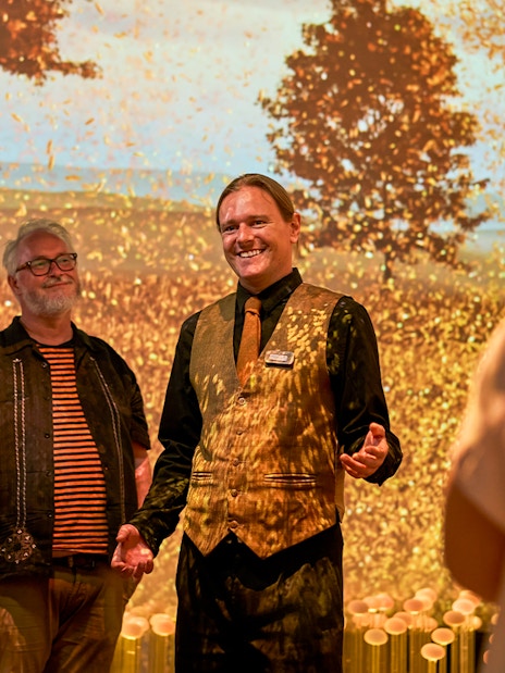 Guide leading visitors on a sensory journey through Scotland with autumn backdrop.