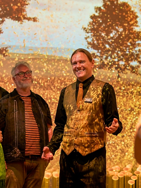 Guide leading visitors on a sensory journey through Scotland with autumn backdrop.