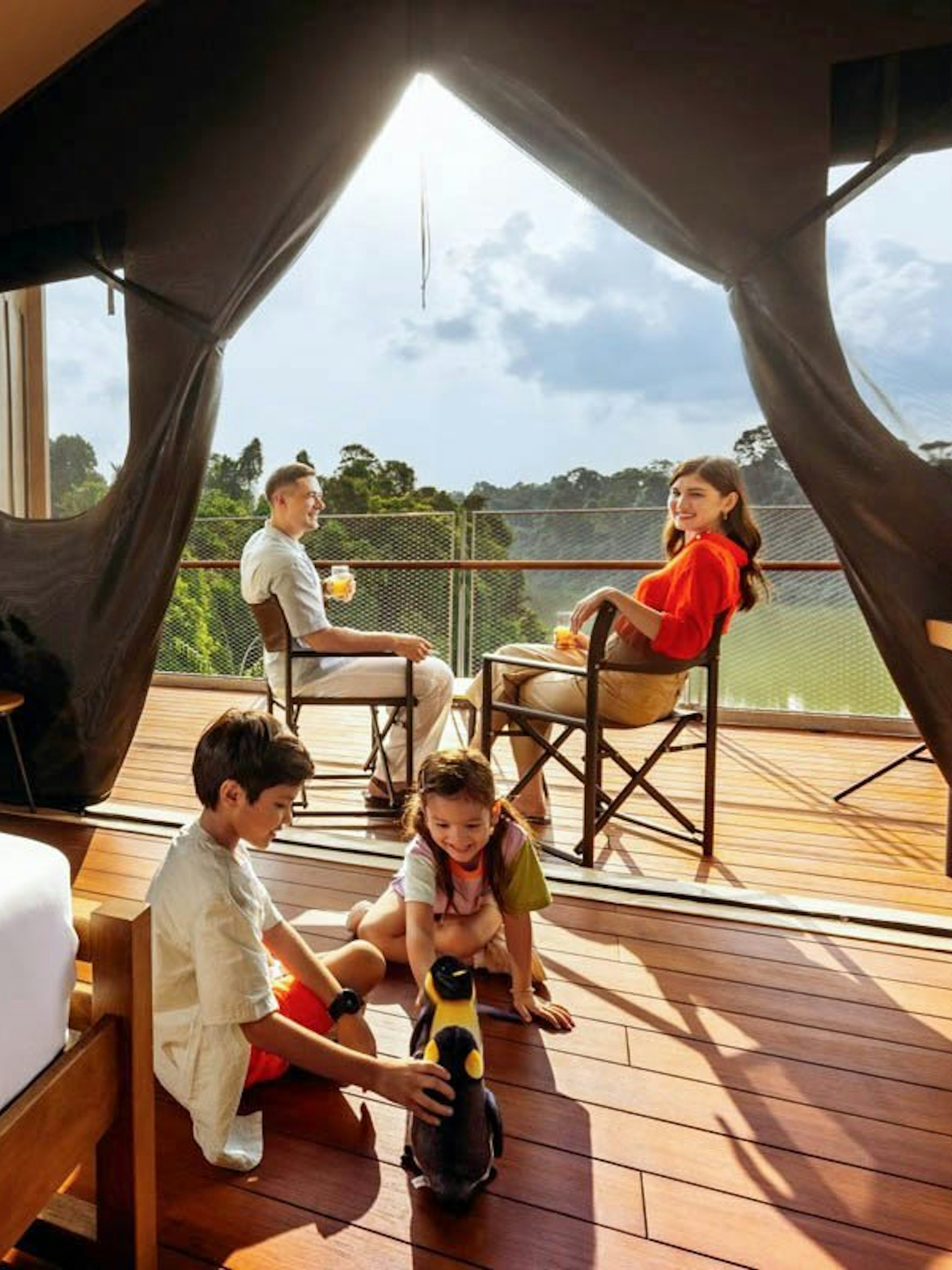 Family enjoying time at Colugo Camp, Mandai Wildlife Reserve, with children playing on the deck.