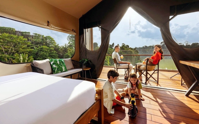 Family enjoying time at Colugo Camp, Mandai Wildlife Reserve, with children playing on the deck.