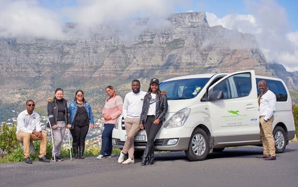Tour group with van in front of Table Mountain, Cape Town.
