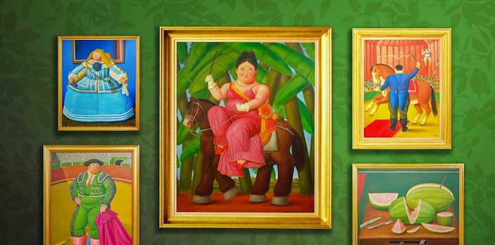 Botero paintings on a green wall, featuring a woman on horseback, a matador, and sliced fruit.
