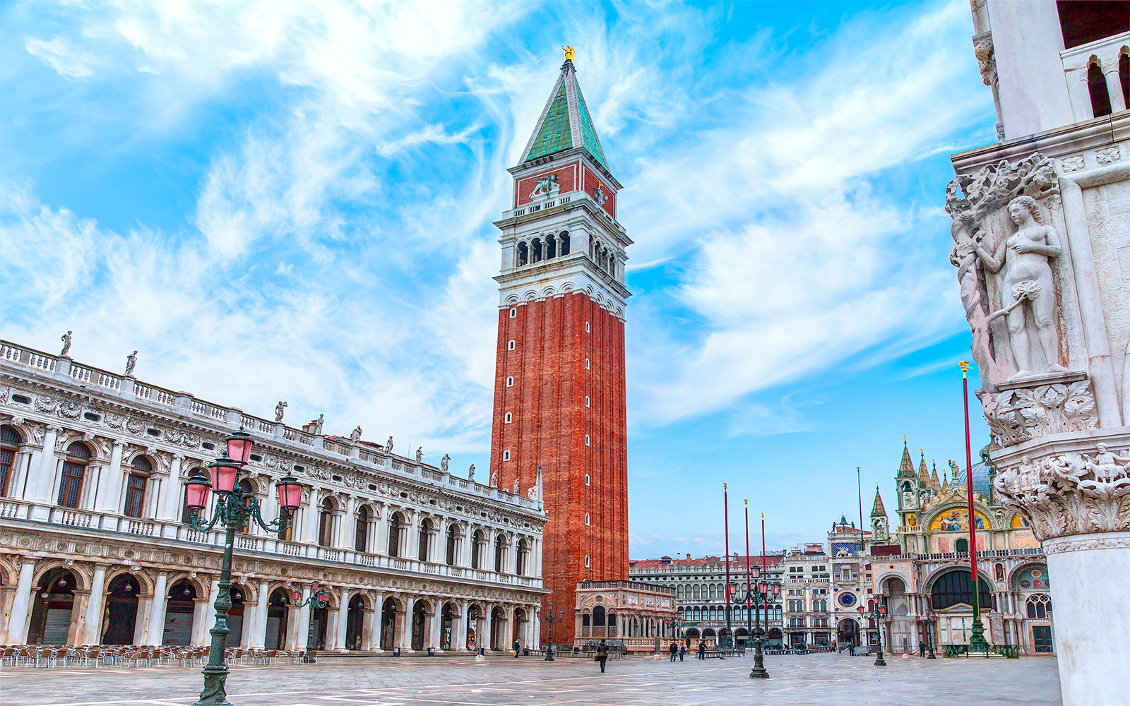 St. Mark's Bell Tower in Venice with tourists admiring the view.