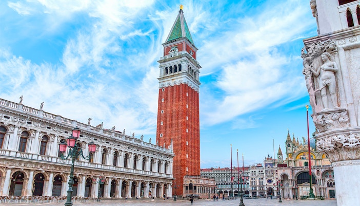 St. Mark's Bell Tower in Venice with tourists admiring the view.