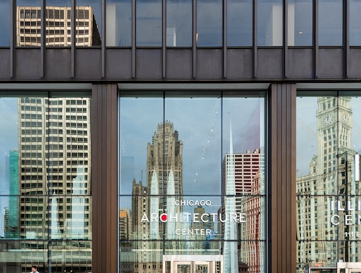 Chicago Architecture Center facade with city reflections and pedestrians.