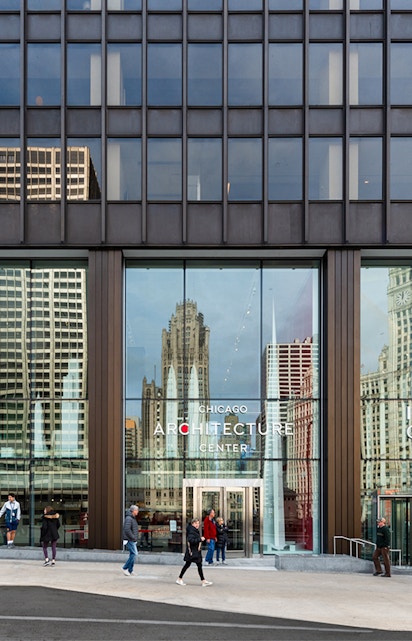 Chicago Architecture Center facade with city reflections and pedestrians.