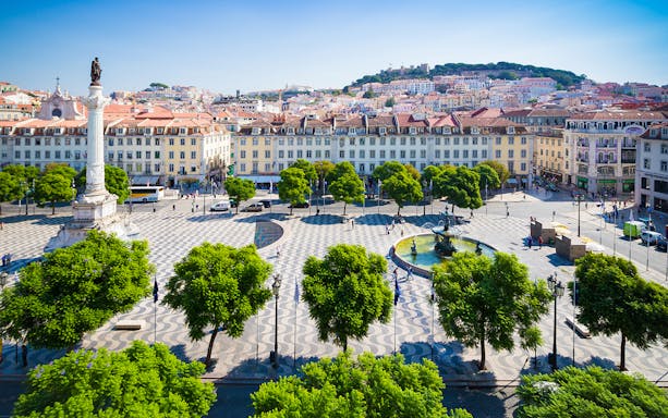 Lisbon's Rossio Square with column and fountain on a guided walking tour.