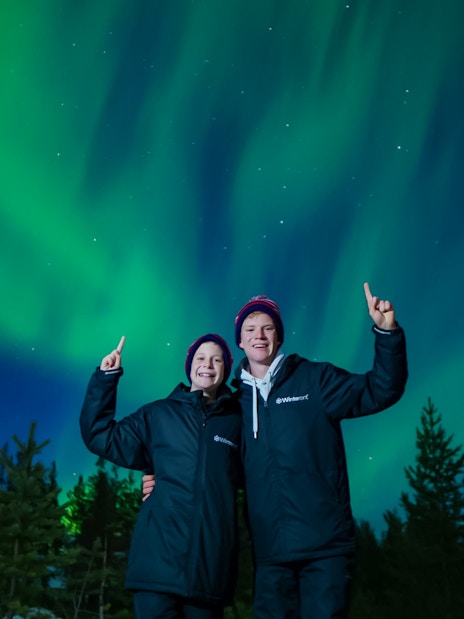 Couple enjoying Northern Lights in Rovaniemi, Finland.
