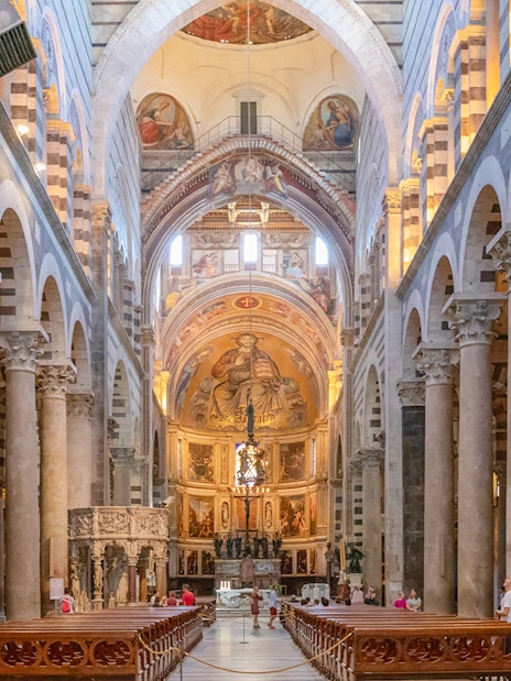 Pisa Cathedral interior with ornate columns and detailed frescoes.