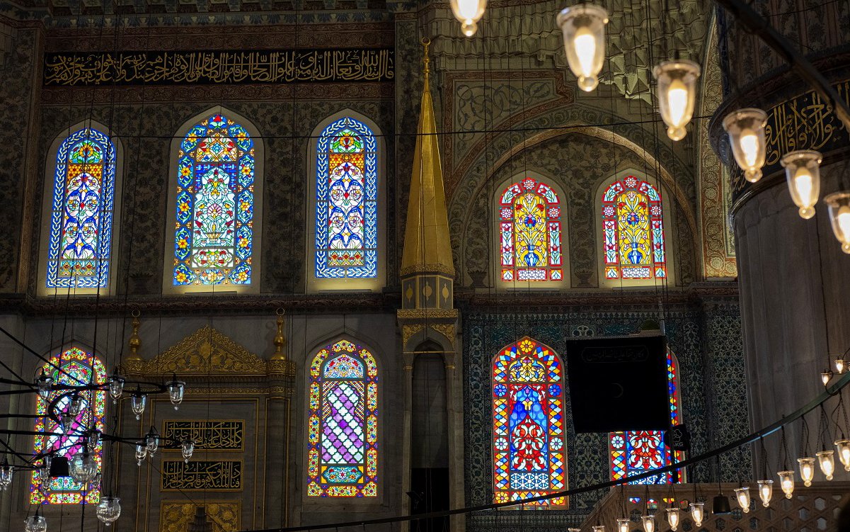 Stained glass windows inside Hagia Sophia, Istanbul, showcasing intricate patterns and vibrant colors.