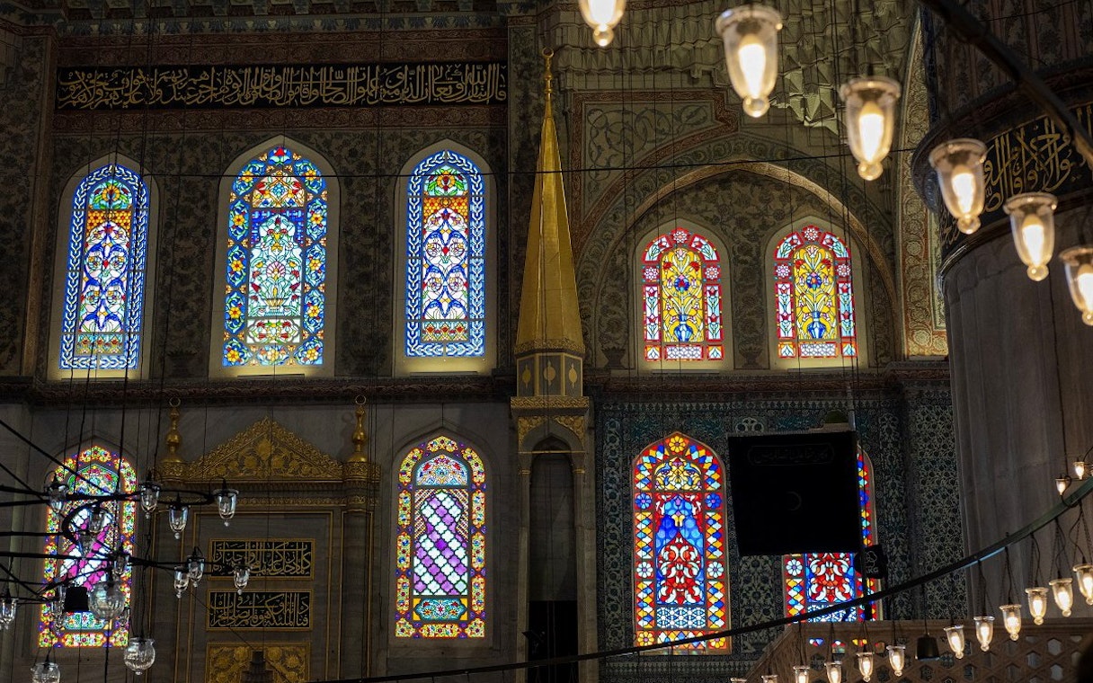 Stained glass windows inside Hagia Sophia, Istanbul, showcasing intricate patterns and vibrant colors.