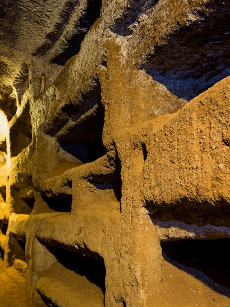 Underground passageway in the Catacombs of Saint Callixtus, Rome, with illuminated niches.