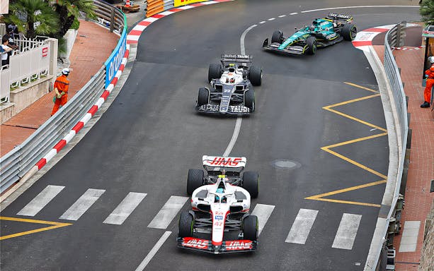 Formula 1 cars racing on a street circuit during the Monaco Grand Prix.