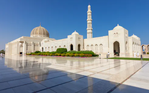 Sultan Qaboos Grand Mosque exterior with dome and minaret, Muscat, Oman.