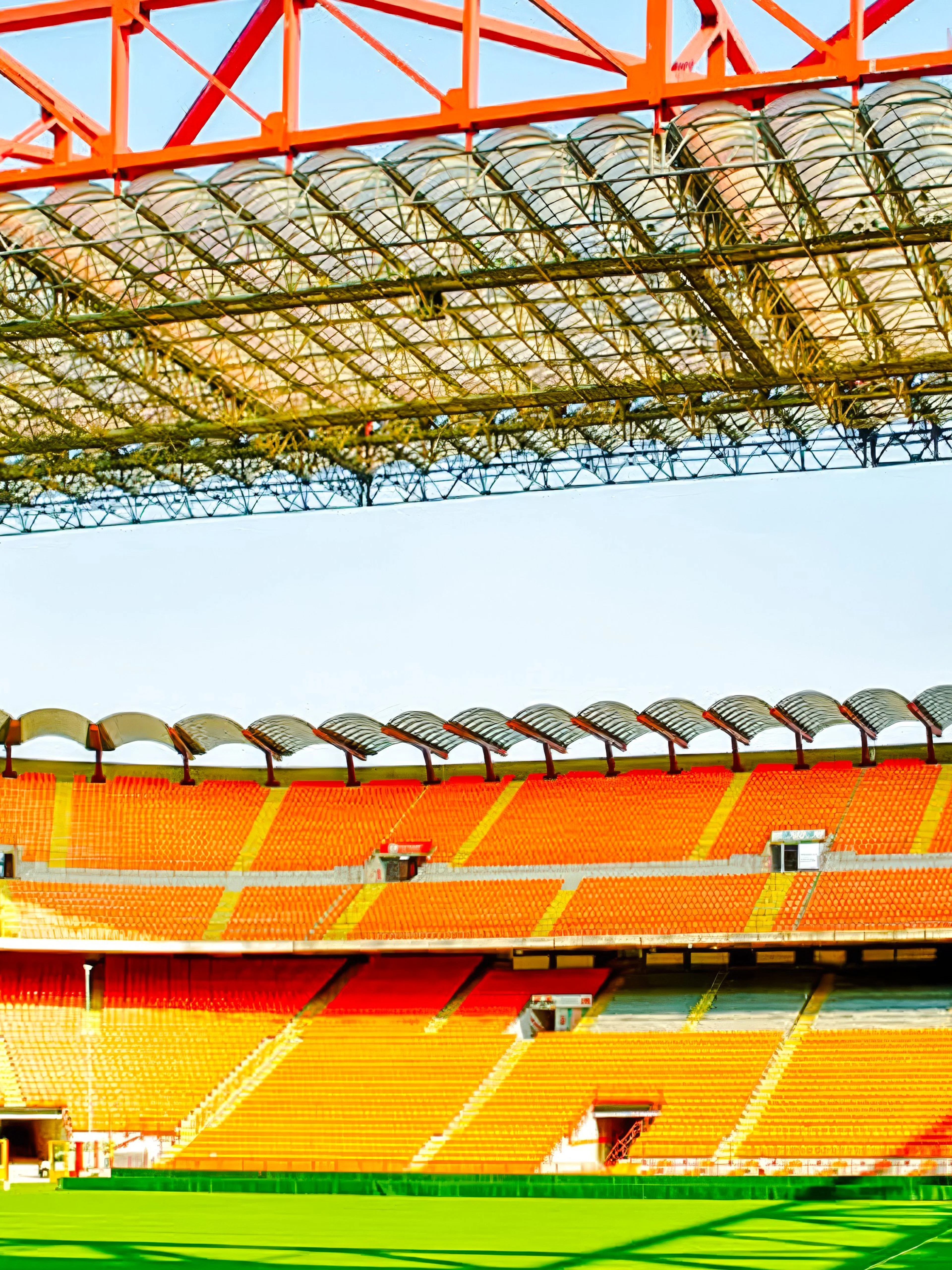 San Siro stadium field with colorful seating and large screen in Milan, Italy.