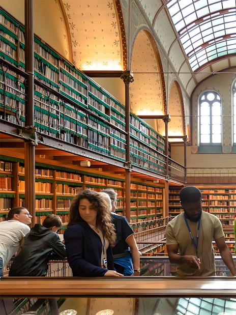 Visitors exploring the library in the Rijksmuseum during a guided tour in Amsterdam.
