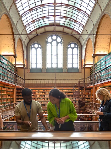 Visitors exploring the library in the Rijksmuseum during a guided tour in Amsterdam.