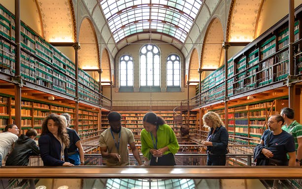 Visitors exploring the library in the Rijksmuseum during a guided tour in Amsterdam.