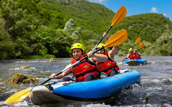 Rafting group navigating river near Split, Croatia, during Rapid Rafting tour.