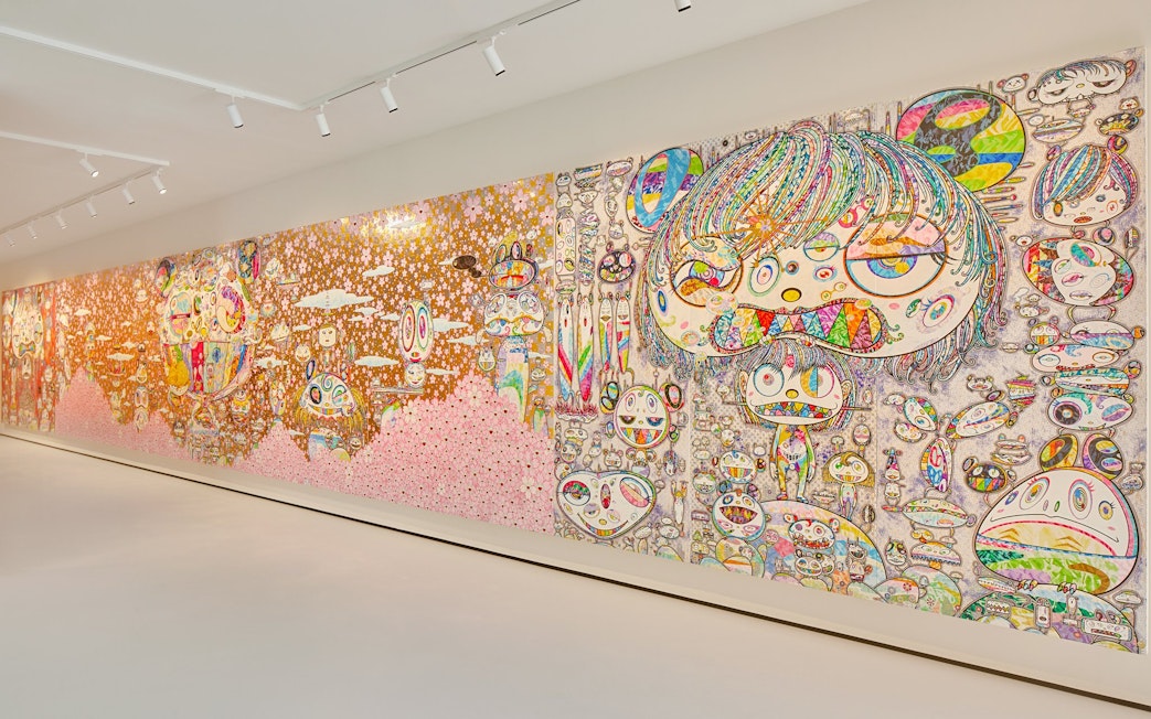 Colorful mural by Yayoi Kusama at Moco Museum London featuring abstract faces and patterns.