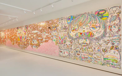 Colorful mural by Yayoi Kusama at Moco Museum London featuring abstract faces and patterns.