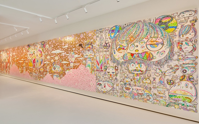 Colorful mural by Yayoi Kusama at Moco Museum London featuring abstract faces and patterns.