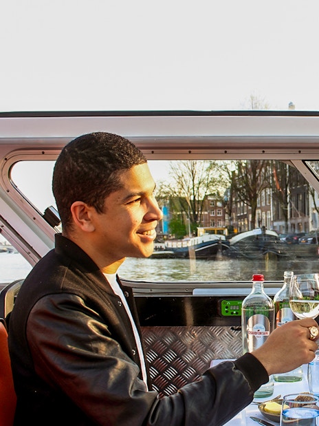 Guests toasting with wine on a canal dinner cruise in Amsterdam.