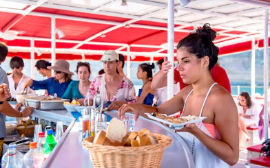 Guests enjoying a barbeque meal on a catamaran cruise in Santorini.
