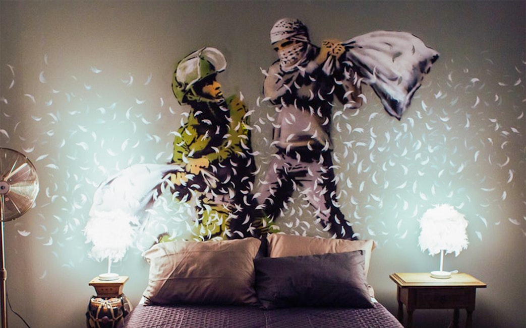 Two figures having a pillow fight, artwork at the Banksy Museum.