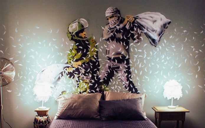 Two figures having a pillow fight, artwork at the Banksy Museum.