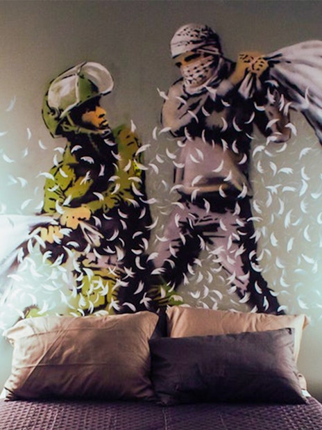 Two figures having a pillow fight, artwork at the Banksy Museum.
