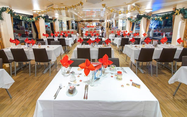 Dining area on Vienna Danube cruise with tables set for guests.