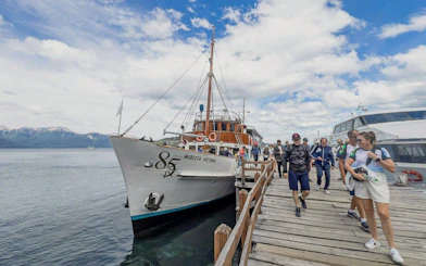Visitors boarding a boat at the pier for the Victoria Island and Arrayanes Forest excursion.