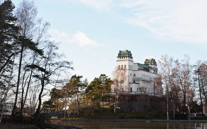 Historic building surrounded by trees in Kulosaari, Finland.