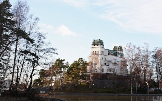 Historic building surrounded by trees in Kulosaari, Finland.