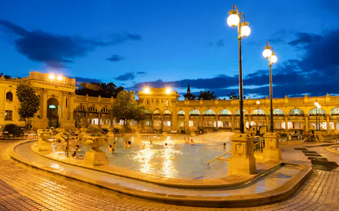 Outdoor pools at Szechenyi Thermal Bath in Budapest during evening.