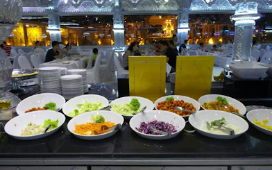 Buffet spread at Phuket FantaSea Show with salads and dining area in background.