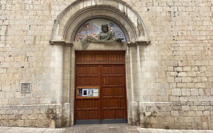 Entrance to the Church of Sant Pere in Figueres, Catalonia, Spain, featuring a wooden door and stone arch.