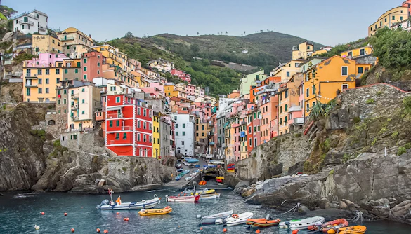 Colorful hillside buildings and boats in the harbor of Riomaggiore, Cinque Terre.