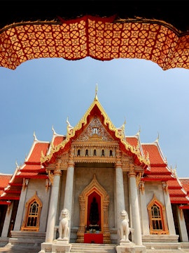 Wat Benchamabophit temple with ornate roof and lion statues, Bangkok, Thailand.
