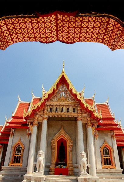 Wat Benchamabophit temple with ornate roof and lion statues, Bangkok, Thailand.