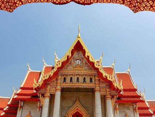 Wat Benchamabophit temple with ornate roof and lion statues, Bangkok, Thailand.