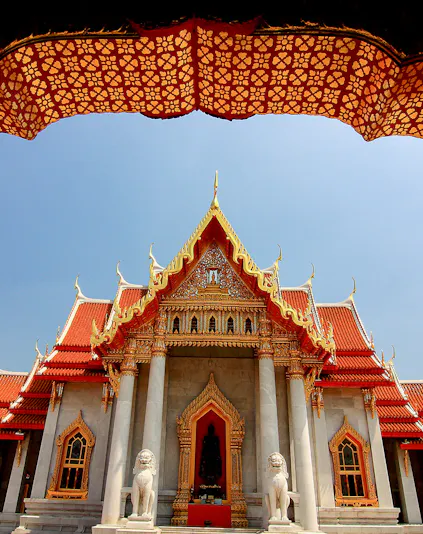 Wat Benchamabophit temple with ornate roof and lion statues, Bangkok, Thailand.