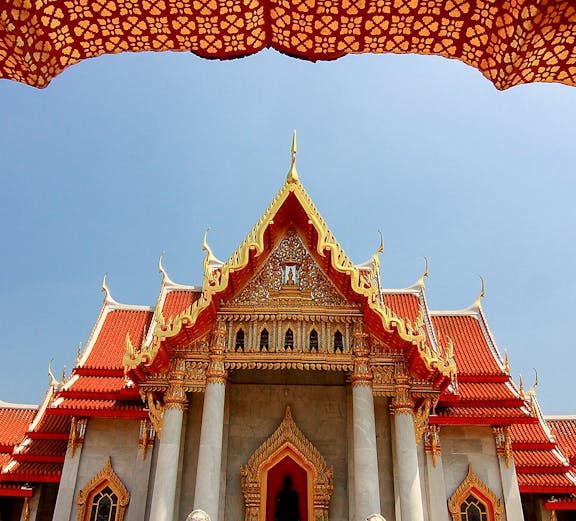 Wat Benchamabophit temple with ornate roof and lion statues, Bangkok, Thailand.