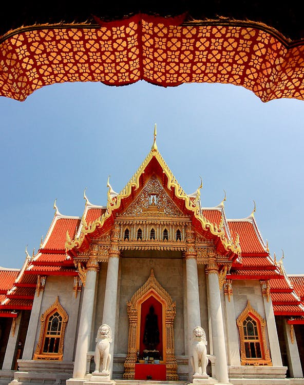 Wat Benchamabophit temple with ornate roof and lion statues, Bangkok, Thailand.