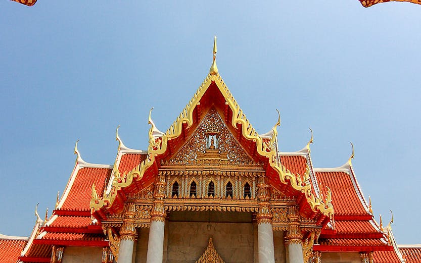 Wat Benchamabophit temple with ornate roof and lion statues, Bangkok, Thailand.