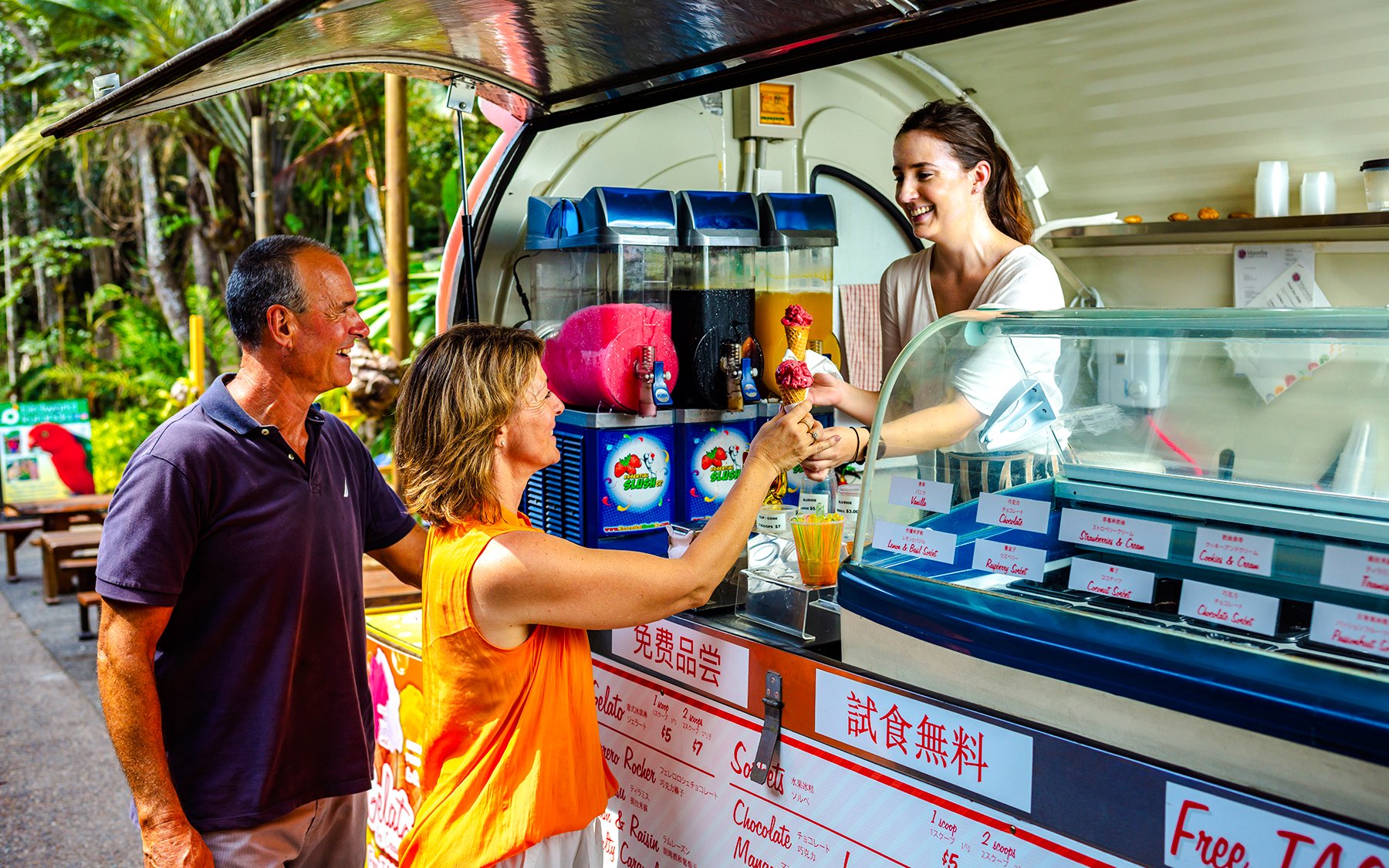 Tourists enjoying ice cream at a Kuranda market stall during the Scenic Train and Skyrail Kuranda Tour.