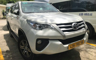 White SUV used for Hue to Da Nang bus service, parked in Dubai.
