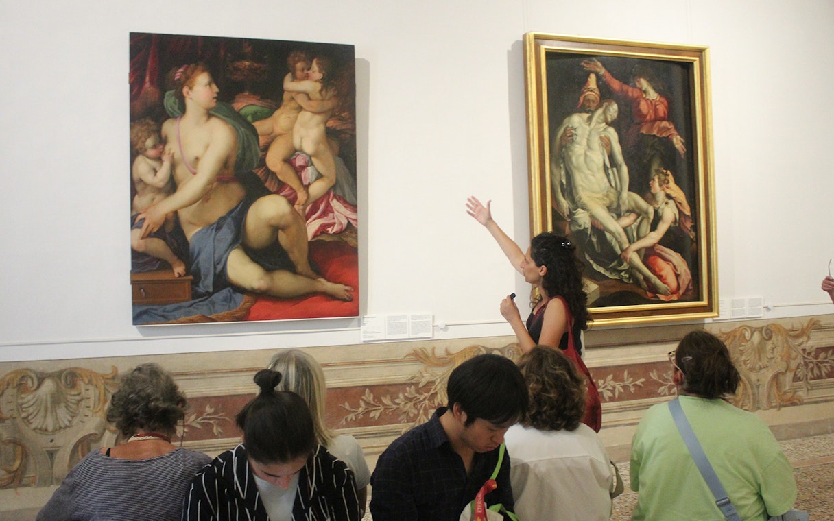 Tour guide explaining paintings to visitors inside Palazzo Barberini, Rome.
