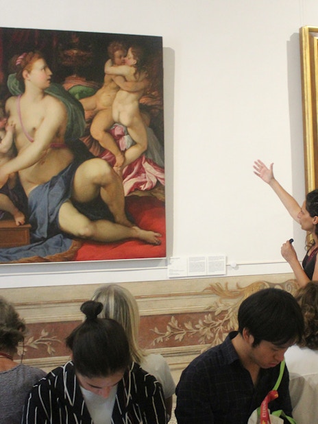 Tour guide explaining paintings to visitors inside Palazzo Barberini, Rome.